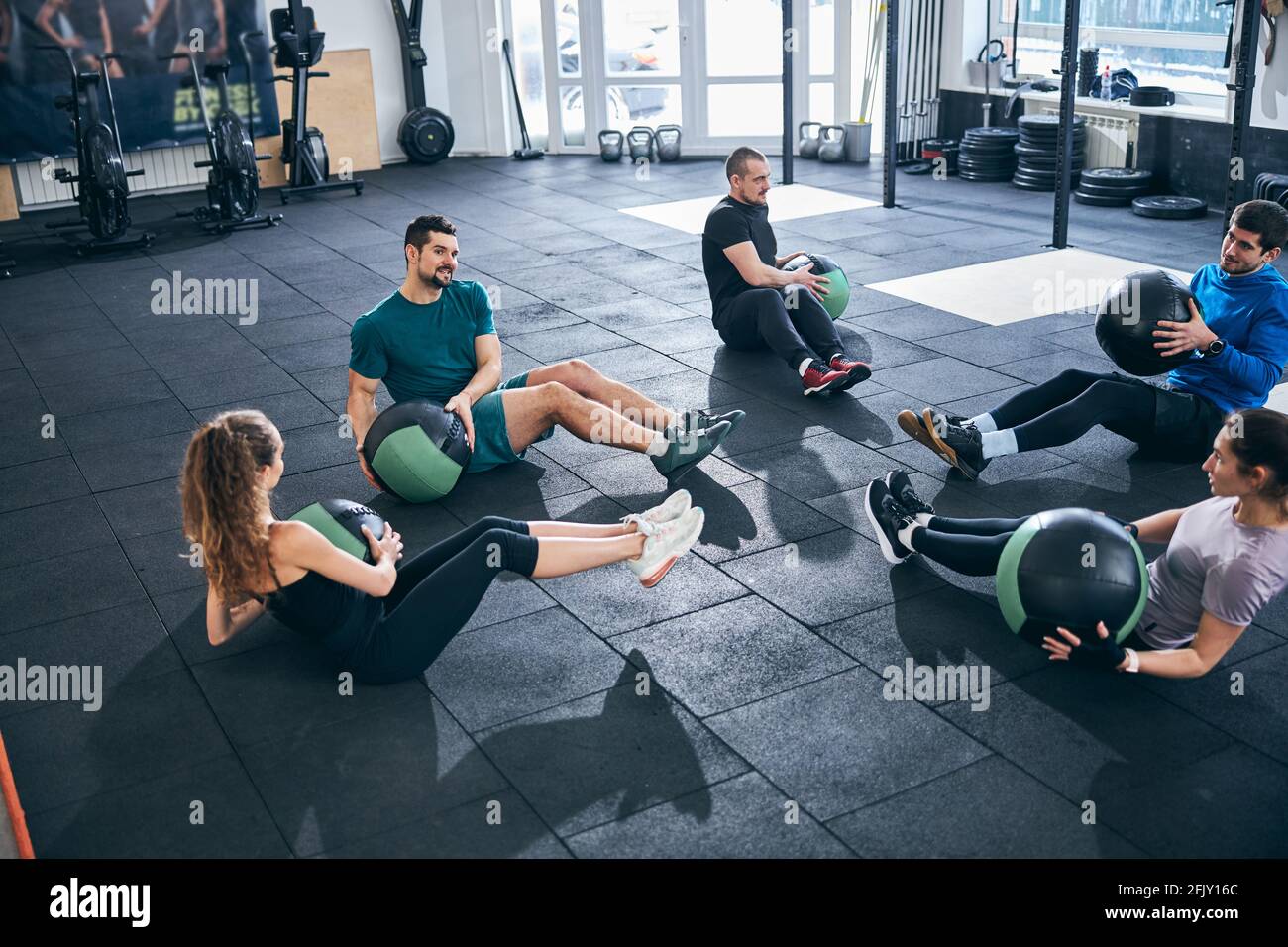 Young people performing the seated trunk rotations Stock Photo