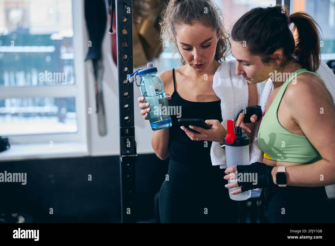 Two concentrated female athletes surfing the net after the workout Stock Photo