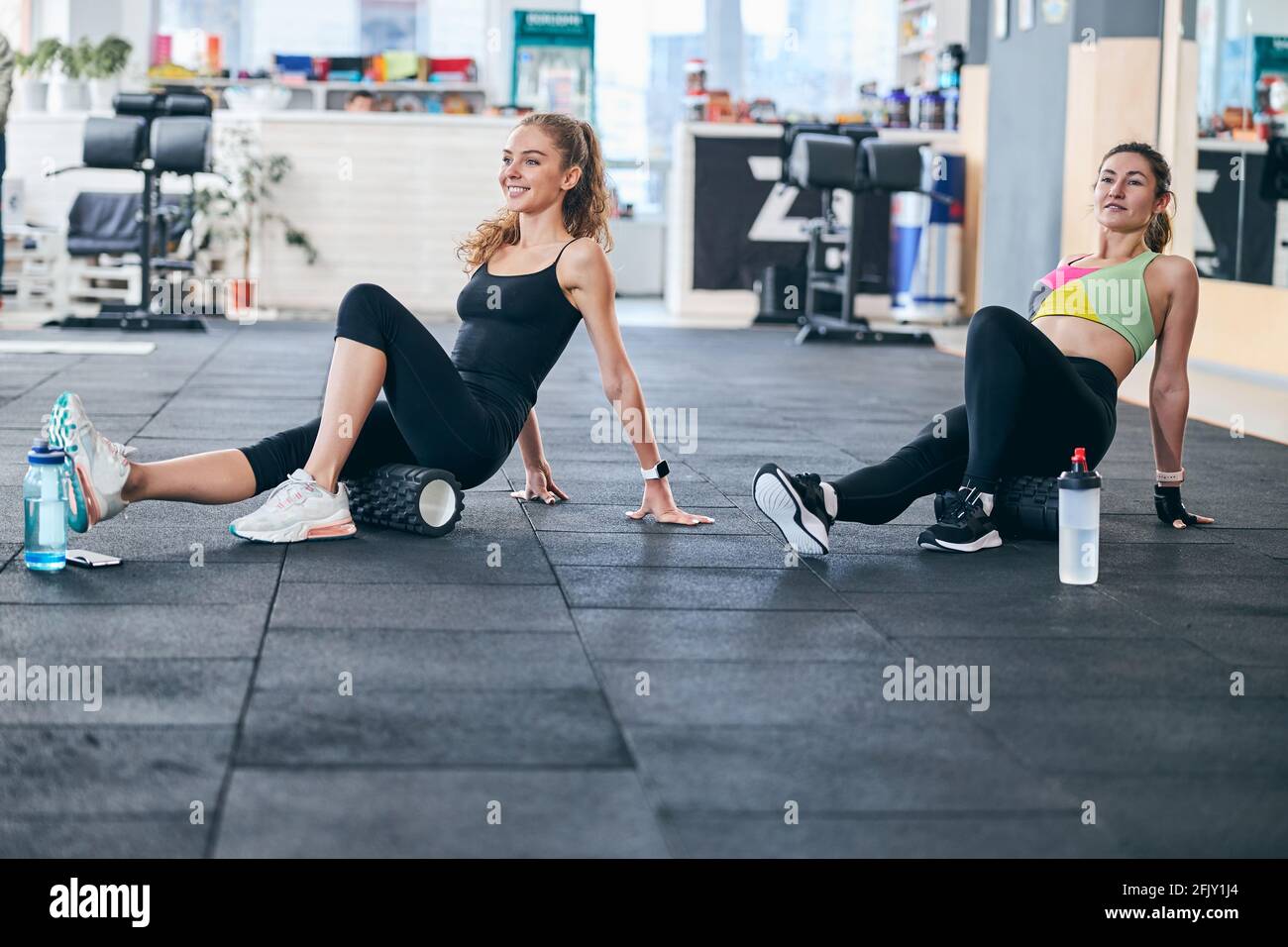 Two women using foam rollers during the workout Stock Photo - Alamy