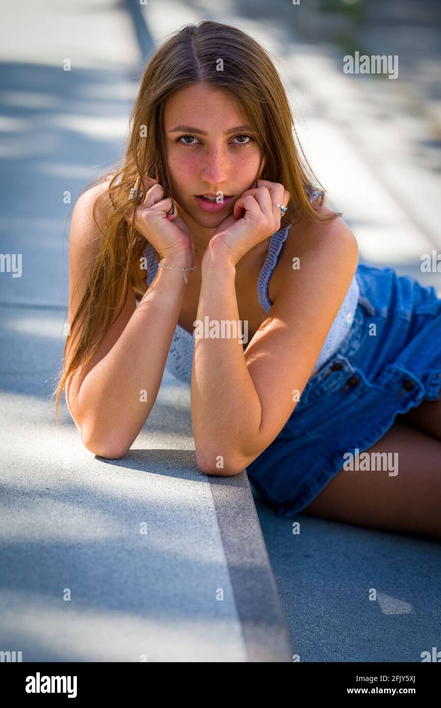 Portrait of young woman seated on long concrete stairs Stock Photo