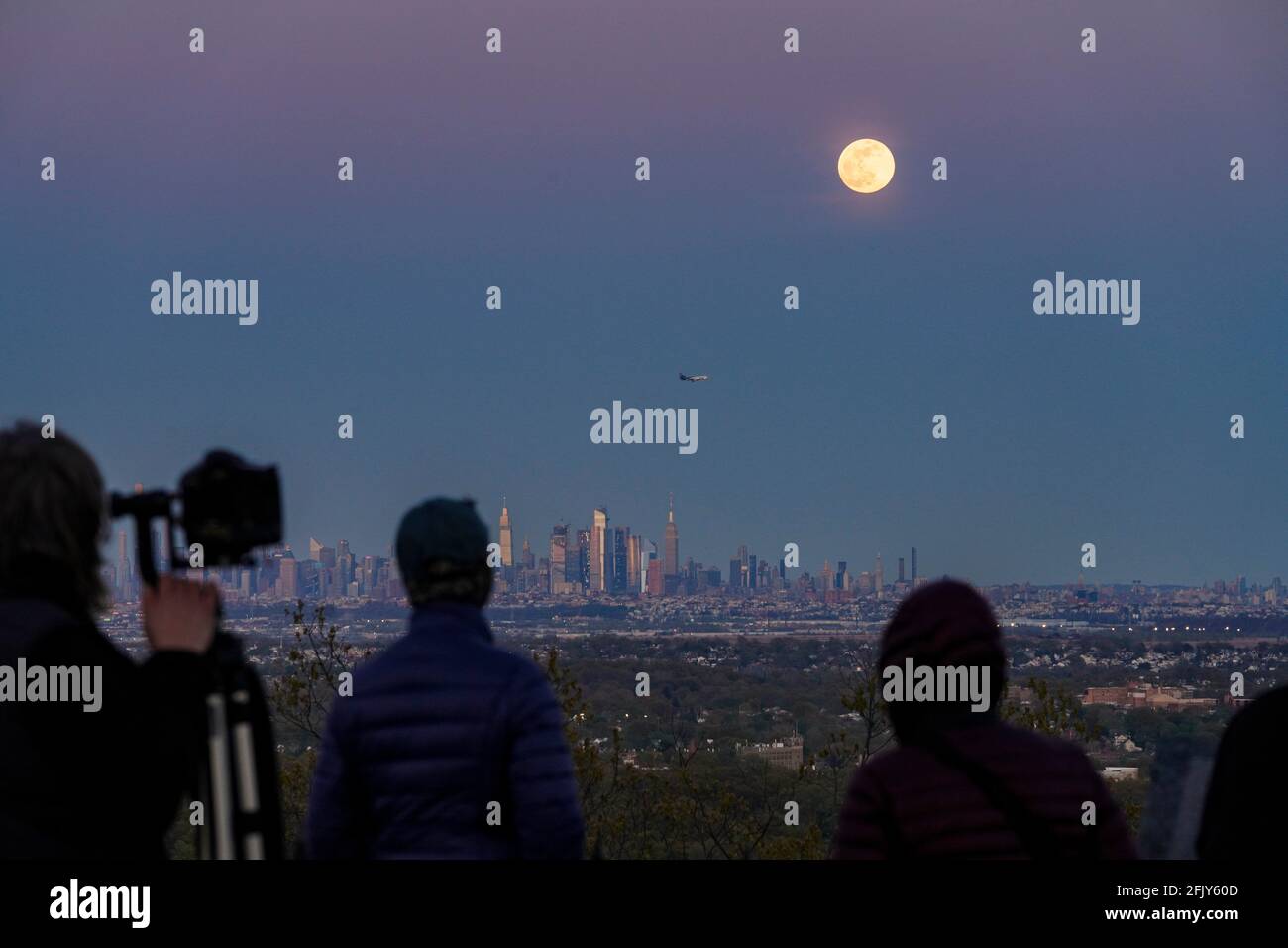 New York, USA. 26th Apr, 2021. People watch a super moon over New York's Manhattan skyline from West Orange of New Jersey, the United States, on April 26, 2021. Credit: Wang Ying/Xinhua/Alamy Live News Stock Photo
