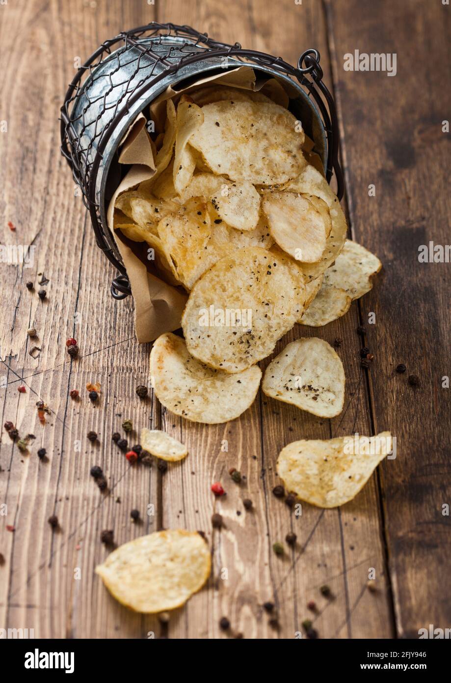 Black pepper taste potato crisps chips in steel snack bucket on wooden  table background. Top view Stock Photo - Alamy