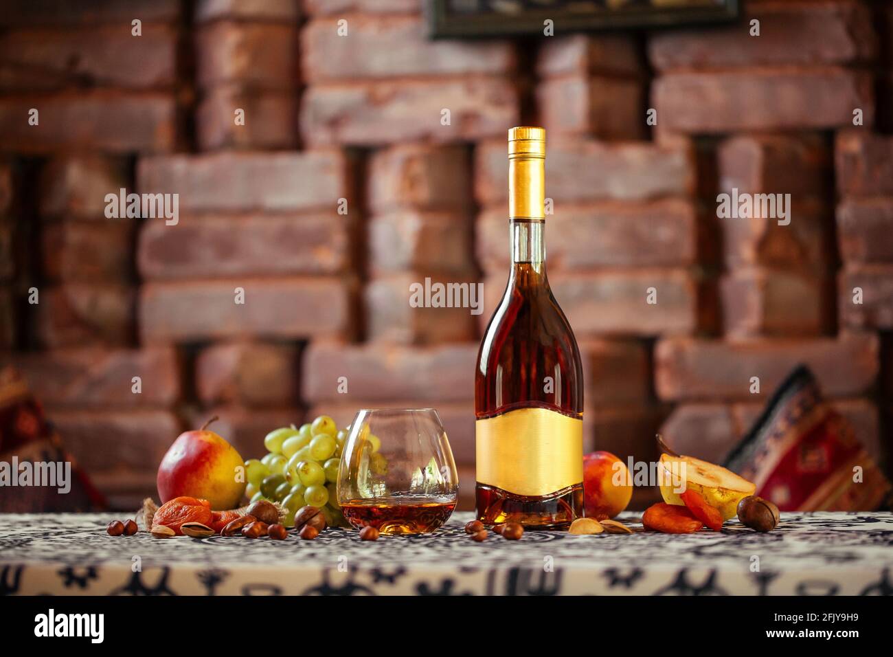 Elegant bottle of cognac with fruits Stock Photo
