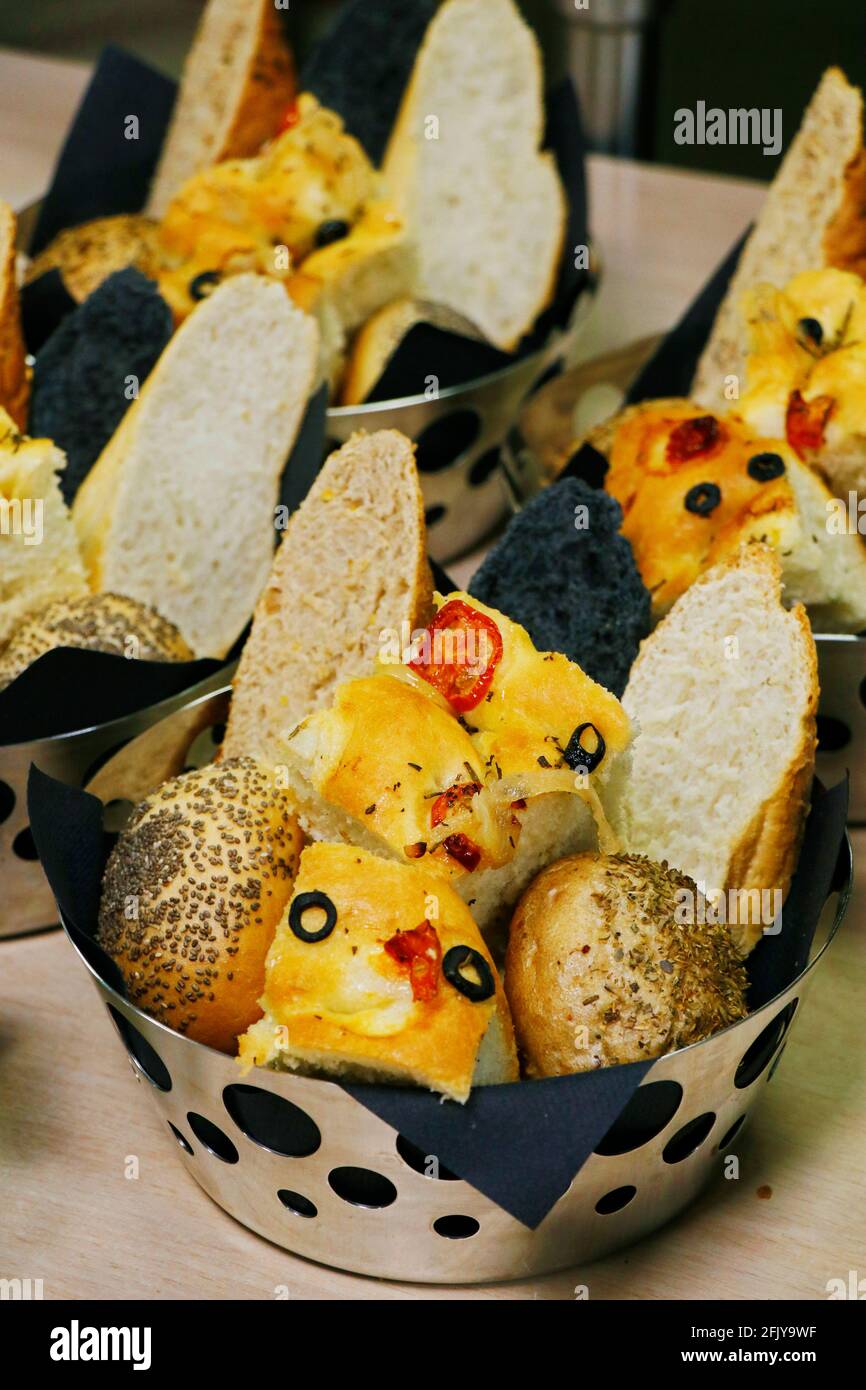 assorted fresh breads in a metal basket Stock Photo
