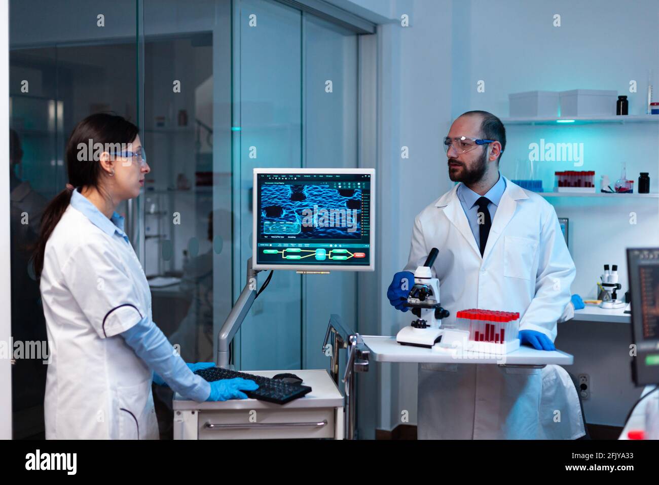 Professional doctor scientist looking in computer analysing DNA image ...