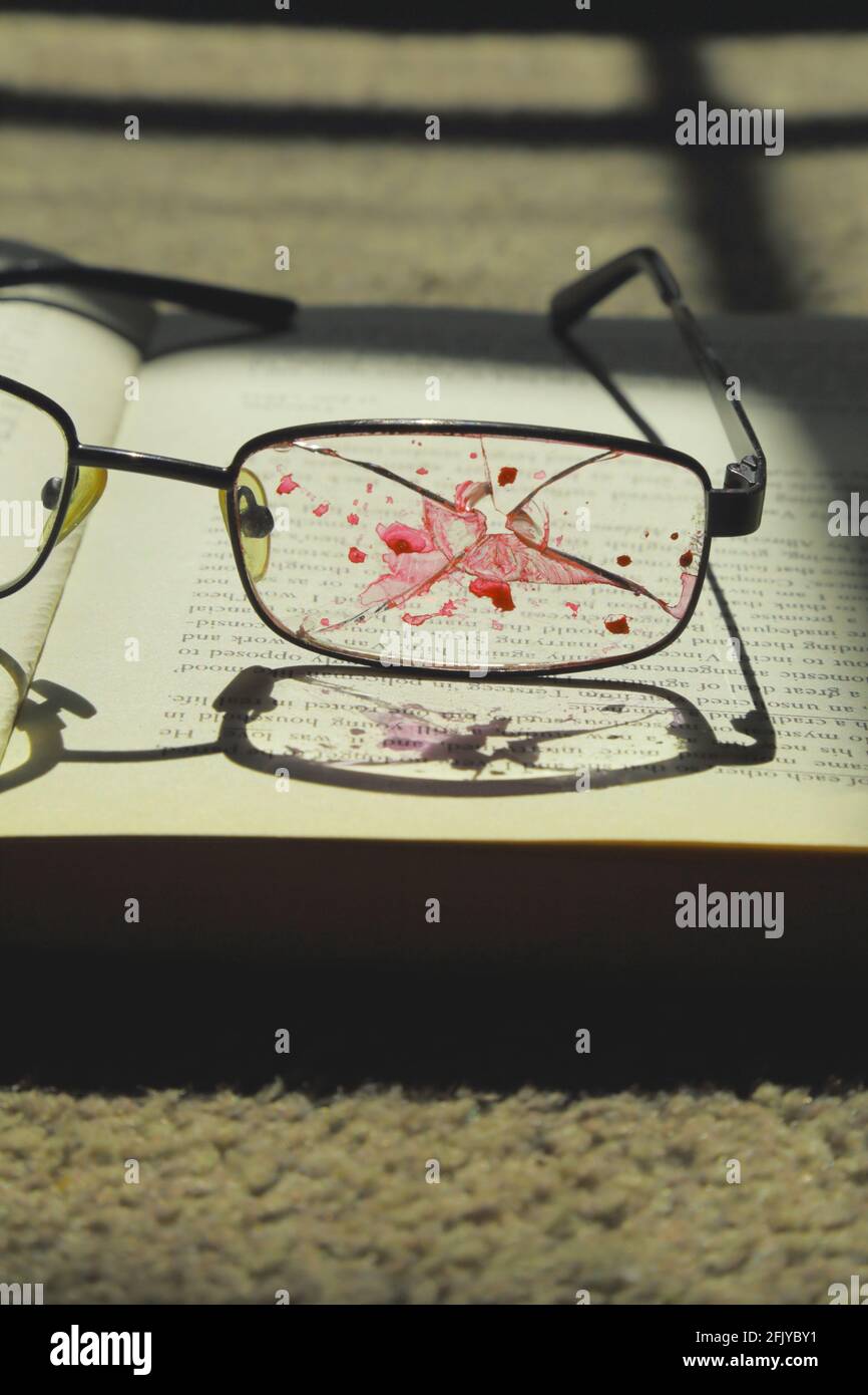 Broken reading glasses with blood. Book cover concept Stock Photo