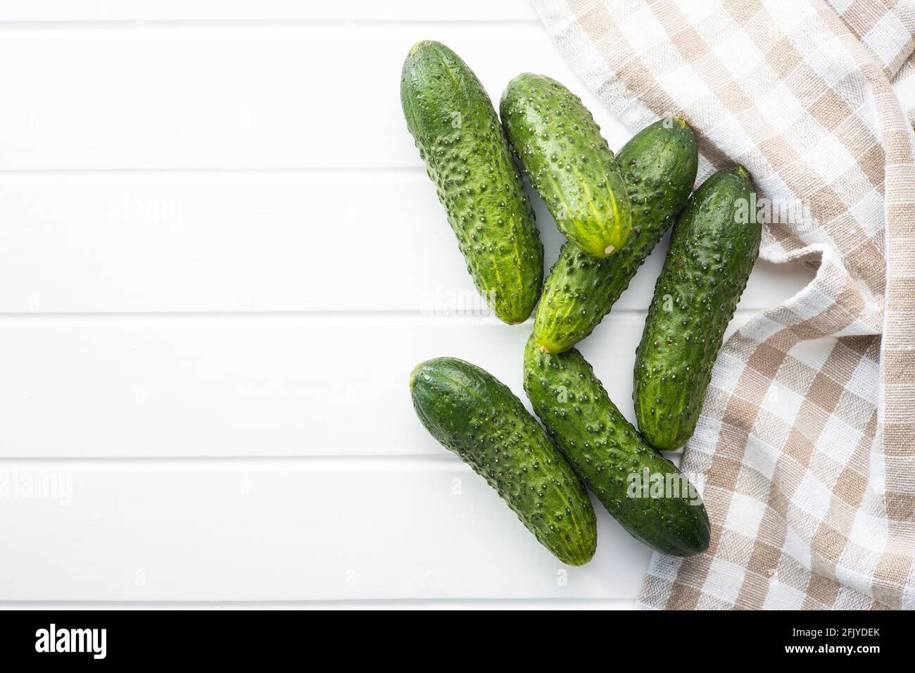 Fresh green cucumbers on white table. Stock Photo