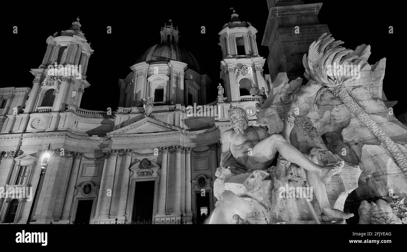 Piazza Navona square Fountain of the Four Rivers and St Agnes Church beautiful baroque monuments illuminated, erected in the 17th century (Black and W Stock Photo