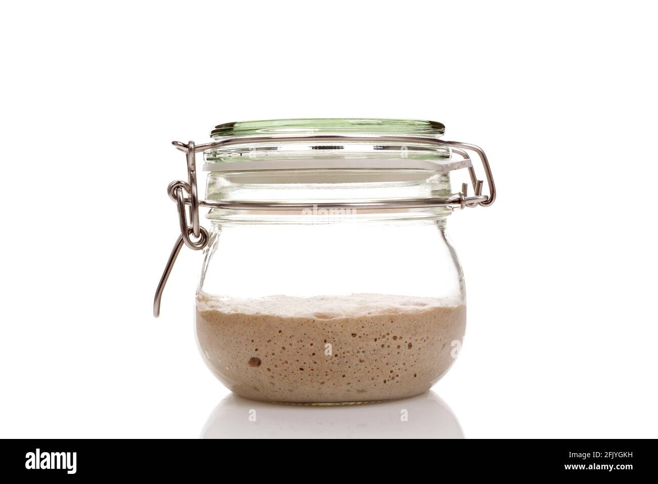 Home made starter yeast growing in a glass jar isolated on white