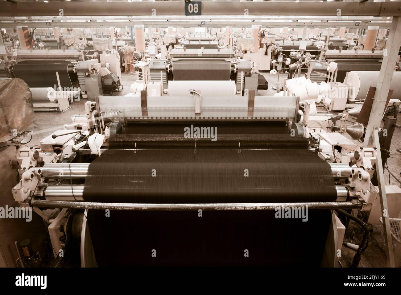 Weaving fabric on air jet looms in big textile weaving unit Stock Photo