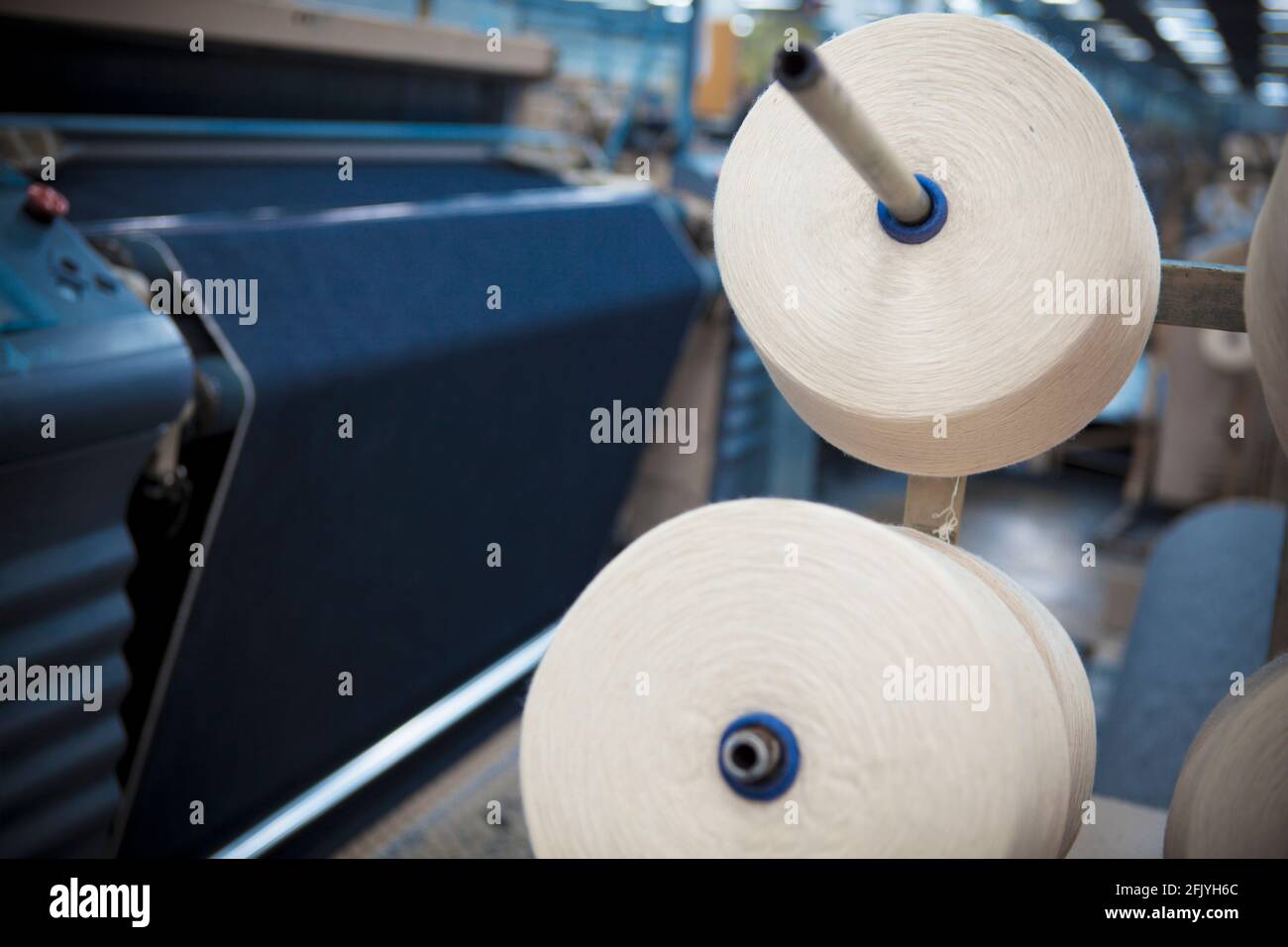 Weaving fabric on air jet looms in big textile weaving unit Stock Photo