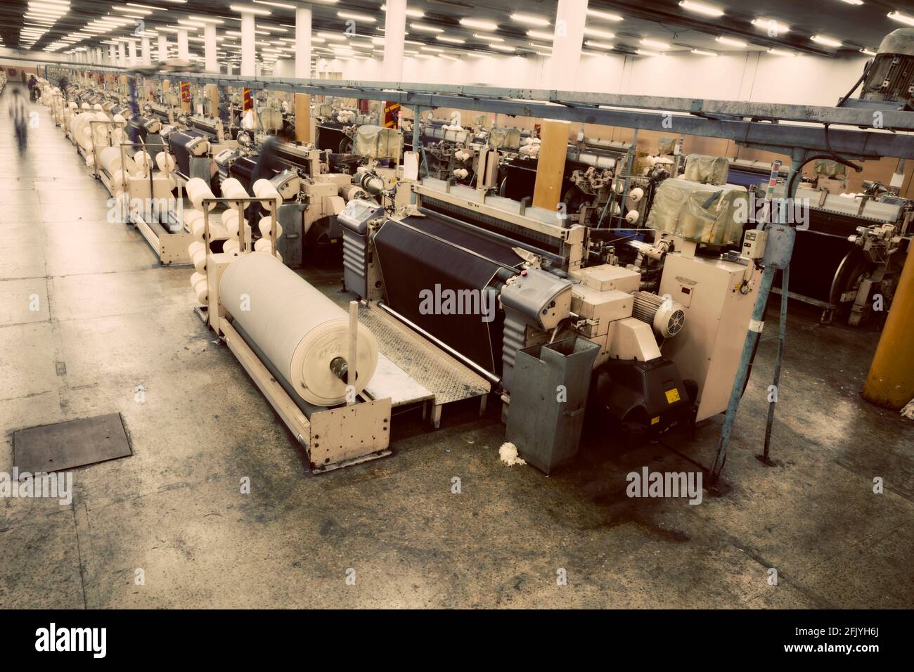 Weaving fabric on air jet looms in big textile weaving unit Stock Photo
