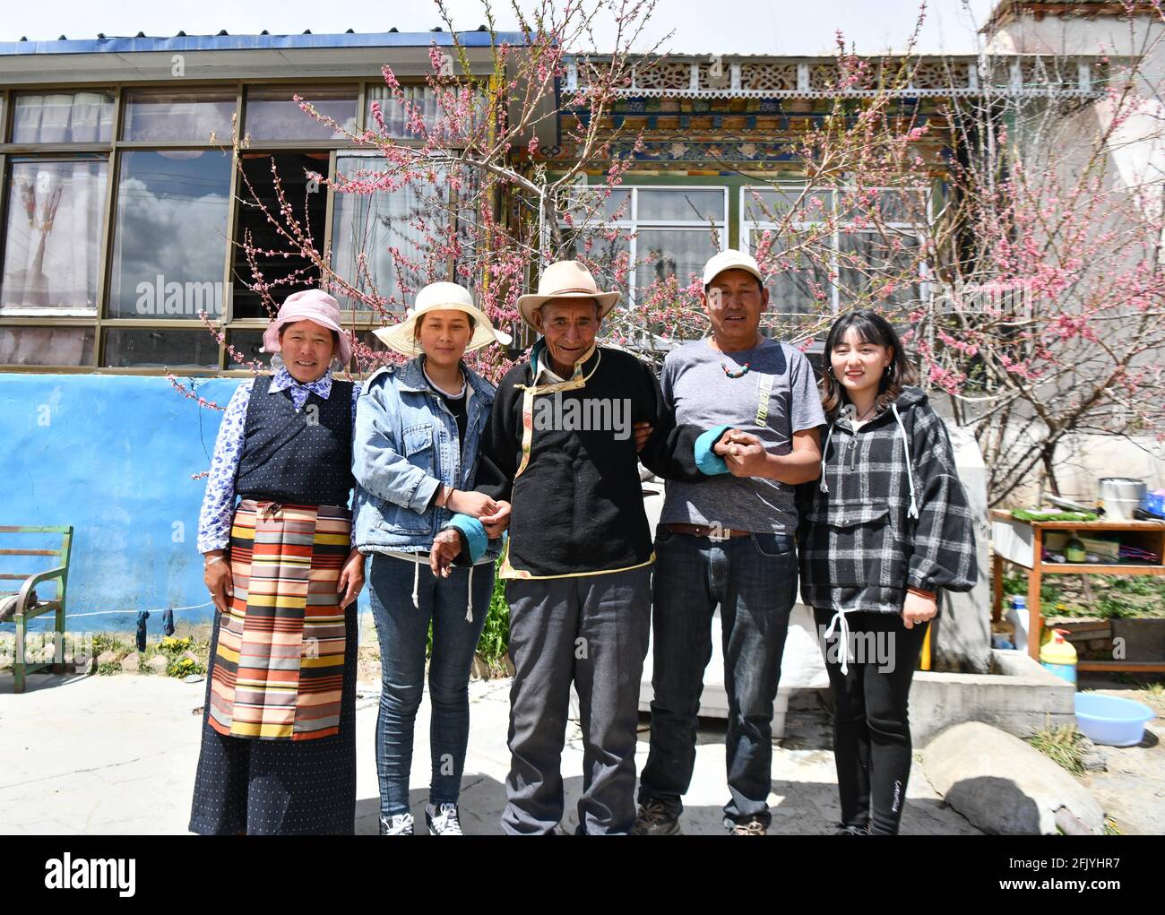 (210427) -- LHASA, April 27, 2021 (Xinhua) -- Lhapu (C) poses for a group photo with his family members in Lin'a Village of Dagze County in Lhasa, southwest China's Tibet Autonomous Region, April 25, 2021. Lhapu, born in 1938, worked as a serf before the democratic reform in Tibet in 1959, which abolished its feudal serfdom under theocracy. "As part of the production tools, we just did what the lord asked us to do, and were even forbidden to speak loudly," Lhapu recalled his life in the old times, adding that children had no guaranteed food and clothing. After the democratic reform, great cha Stock Photo