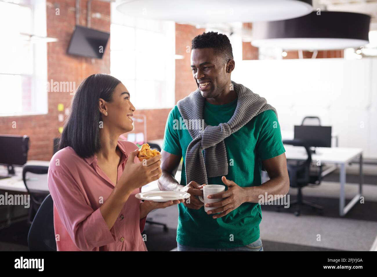 Happy diverse business colleagues on break, having coffee and snack in office Stock Photo
