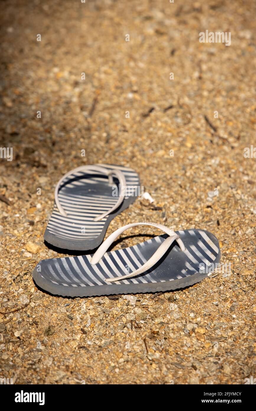 Pair of Jandals or Thongs left on the Sandy Beach of Lake Hayes, South Island. New Zealand Stock Photo