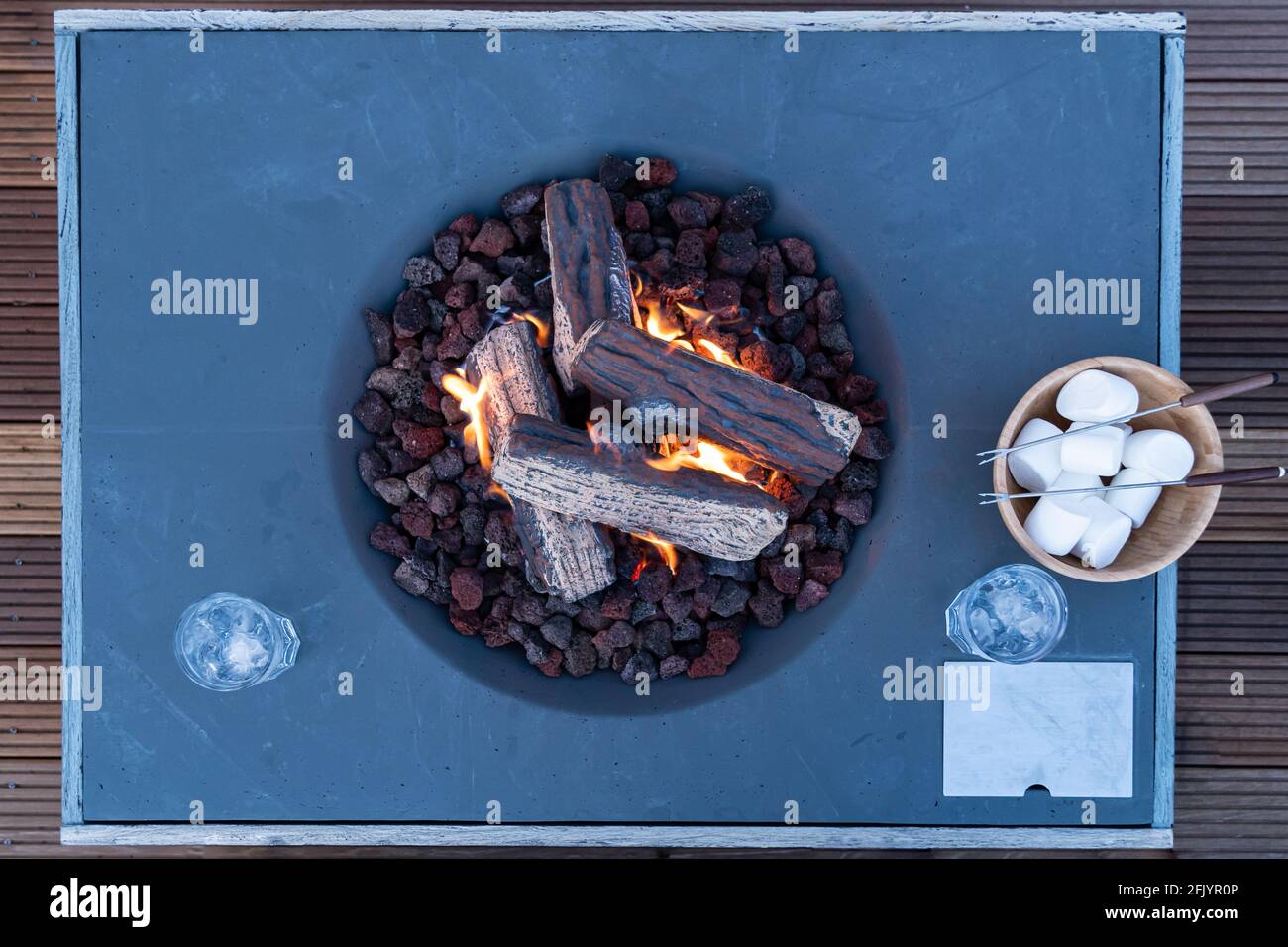 Roasting marshmallow over a gas fire while glamping Stock Photo