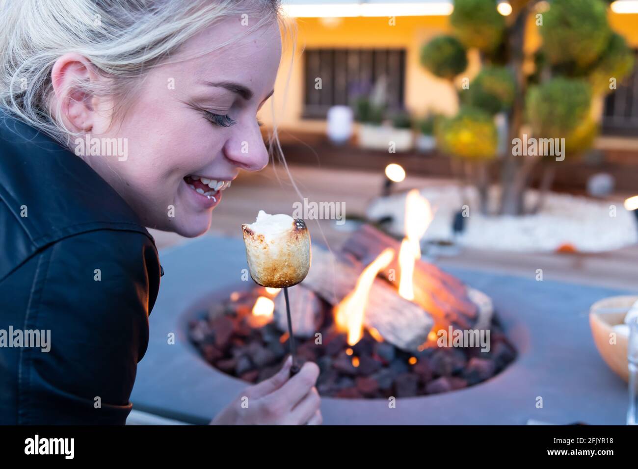 Roasting marshmallow over a gas fire while glamping Stock Photo