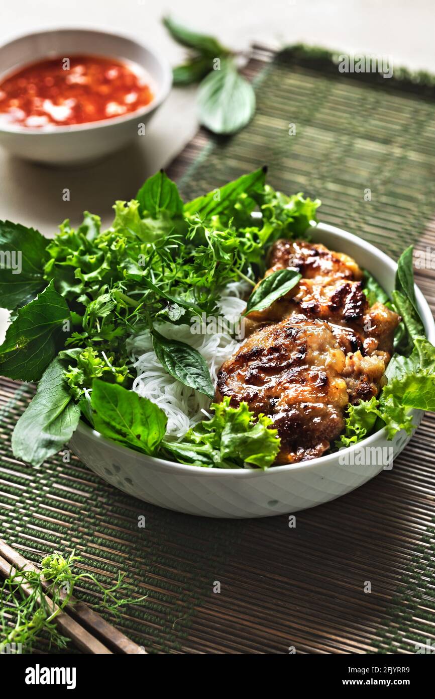 Vietnamese Rice Noodles with Grilled Pork and fresh vegetables and Chilli Sauce Stock Photo