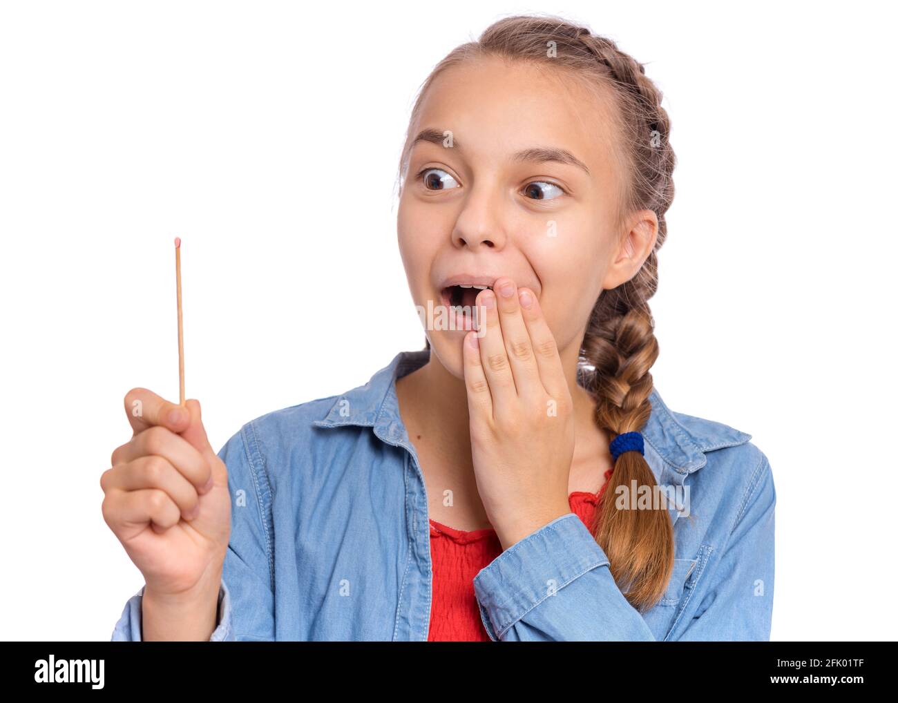 Teen girl holding big match, isolated on white background. Smiling child plays with matches. Fire dangerous concept Stock Photo
