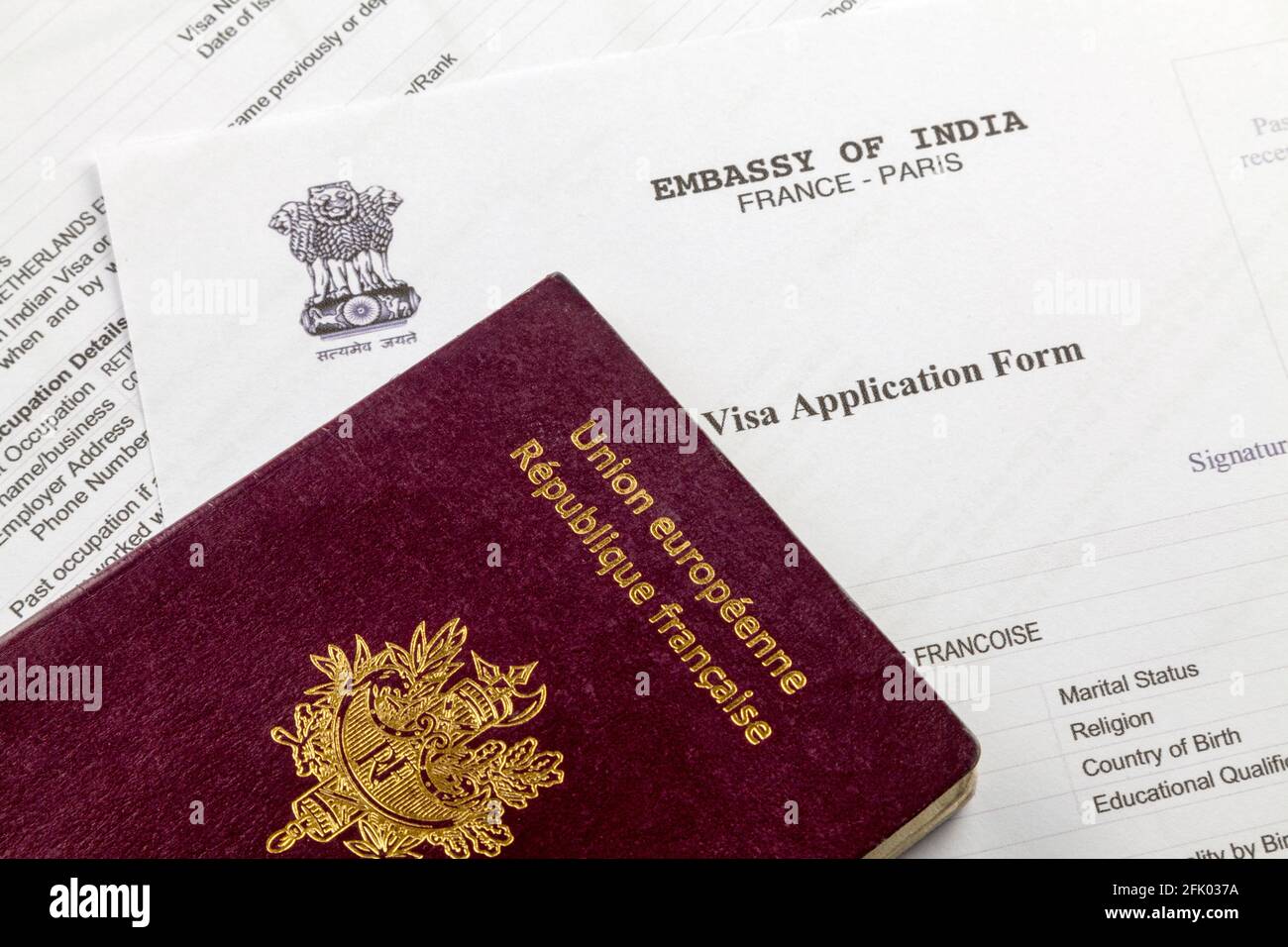 A French passport on the top of an Indian visa application form. Stock Photo