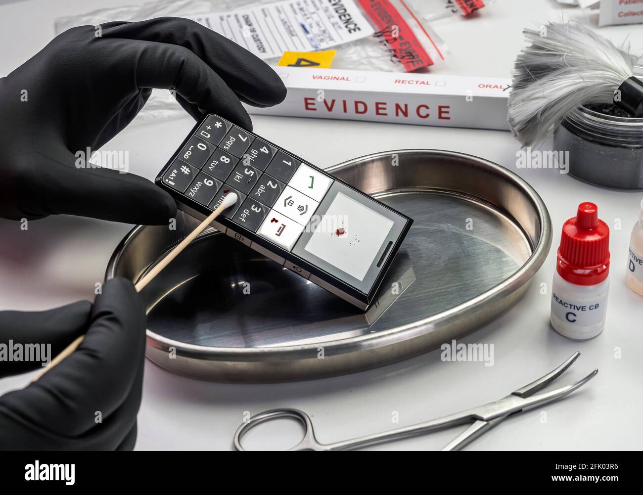 Police scientist extracts traces of blood from mobile phone involved in homicide in lab, conceptual image Stock Photo
