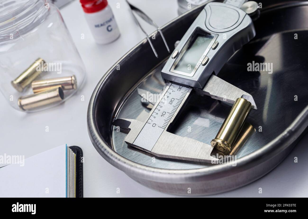 measures bullet caliber in ballistic lab, conceptual image Stock Photo