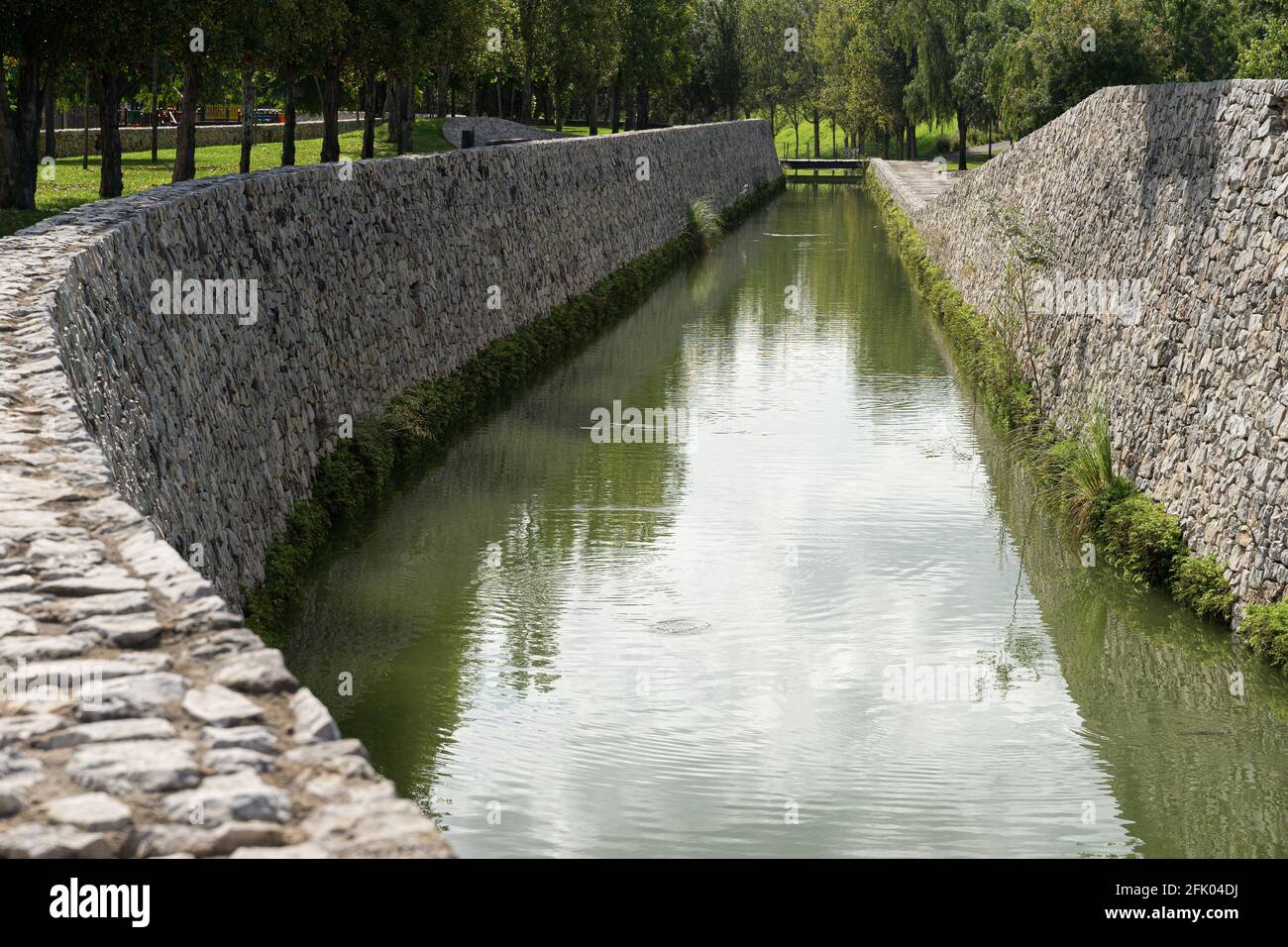 Beautiful green urban park. Public park with green grass fields, trees, waterways and pond. Parque de Cabecera, Valencia, Spain Stock Photo