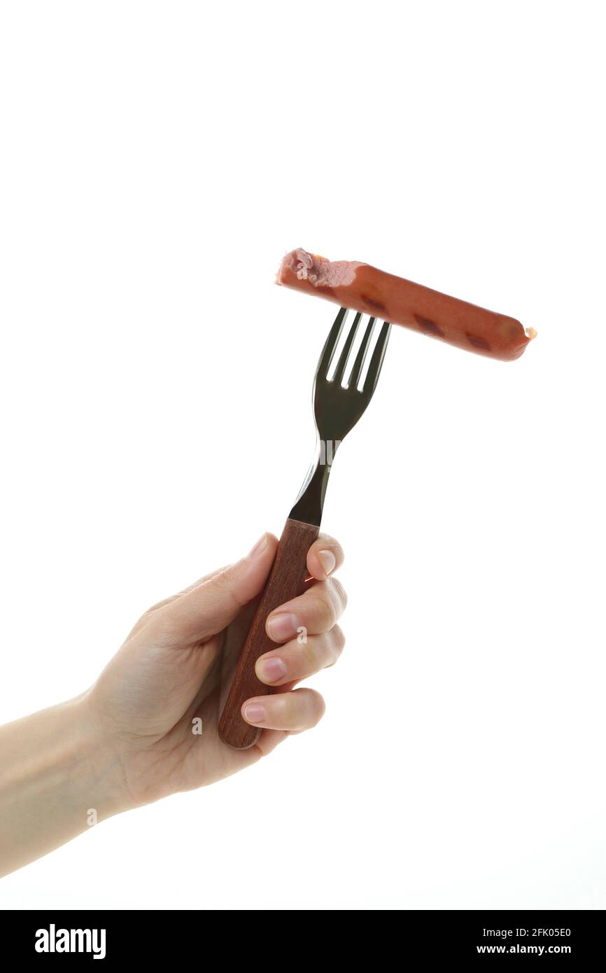 Female hand hold fork with grilled sausage, isolated on white background Stock Photo