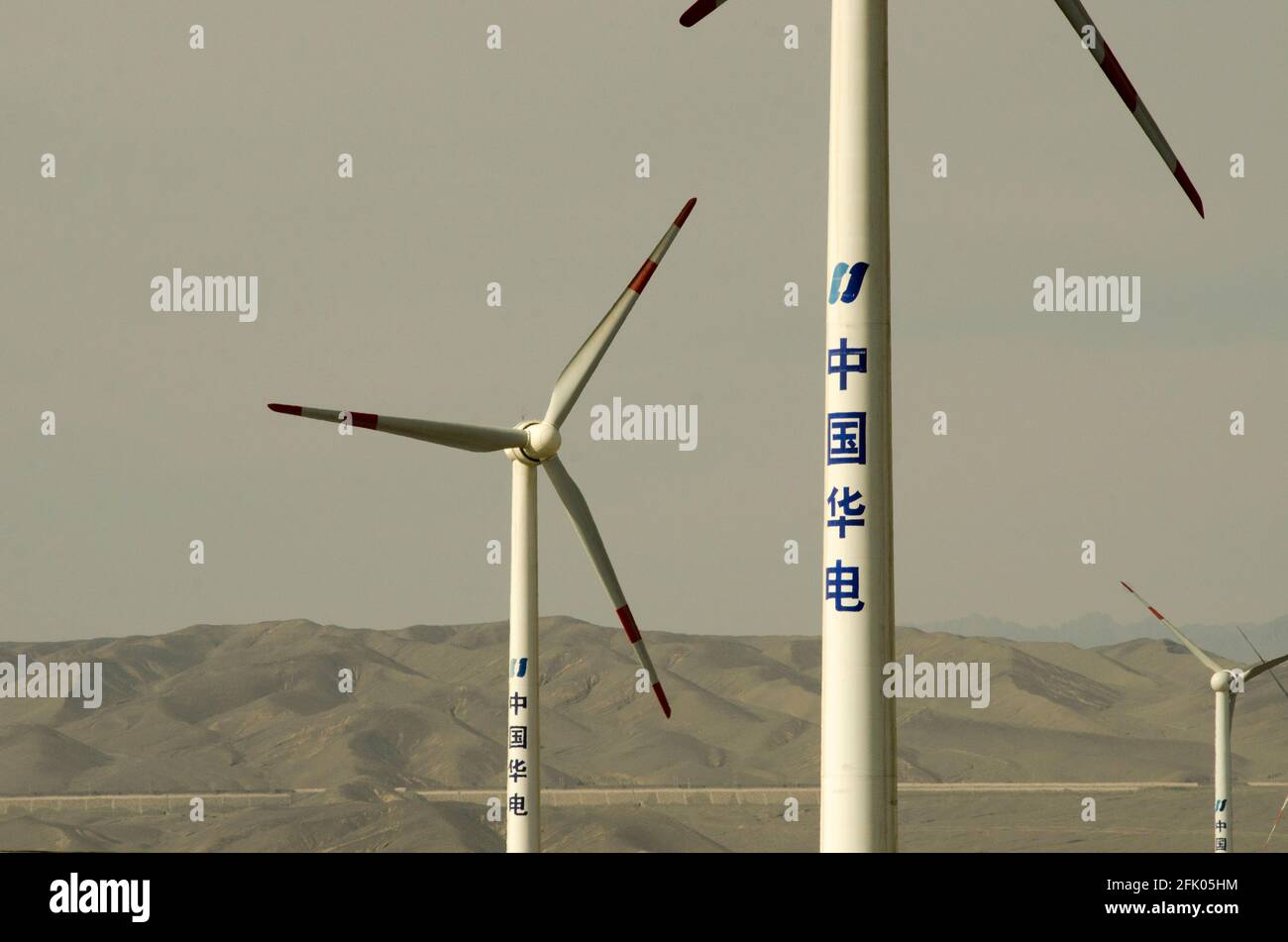 Wind turbines and power lines crisscross the desert on the western outskirts of Turpan, in one of the hottest places on earth. Renewable energy from wind is increasingly used by the Chinese to expand their power-hungry industries, as seen here in Eastern Xinjiang, China, PRC. © Time-Snaps Stock Photo