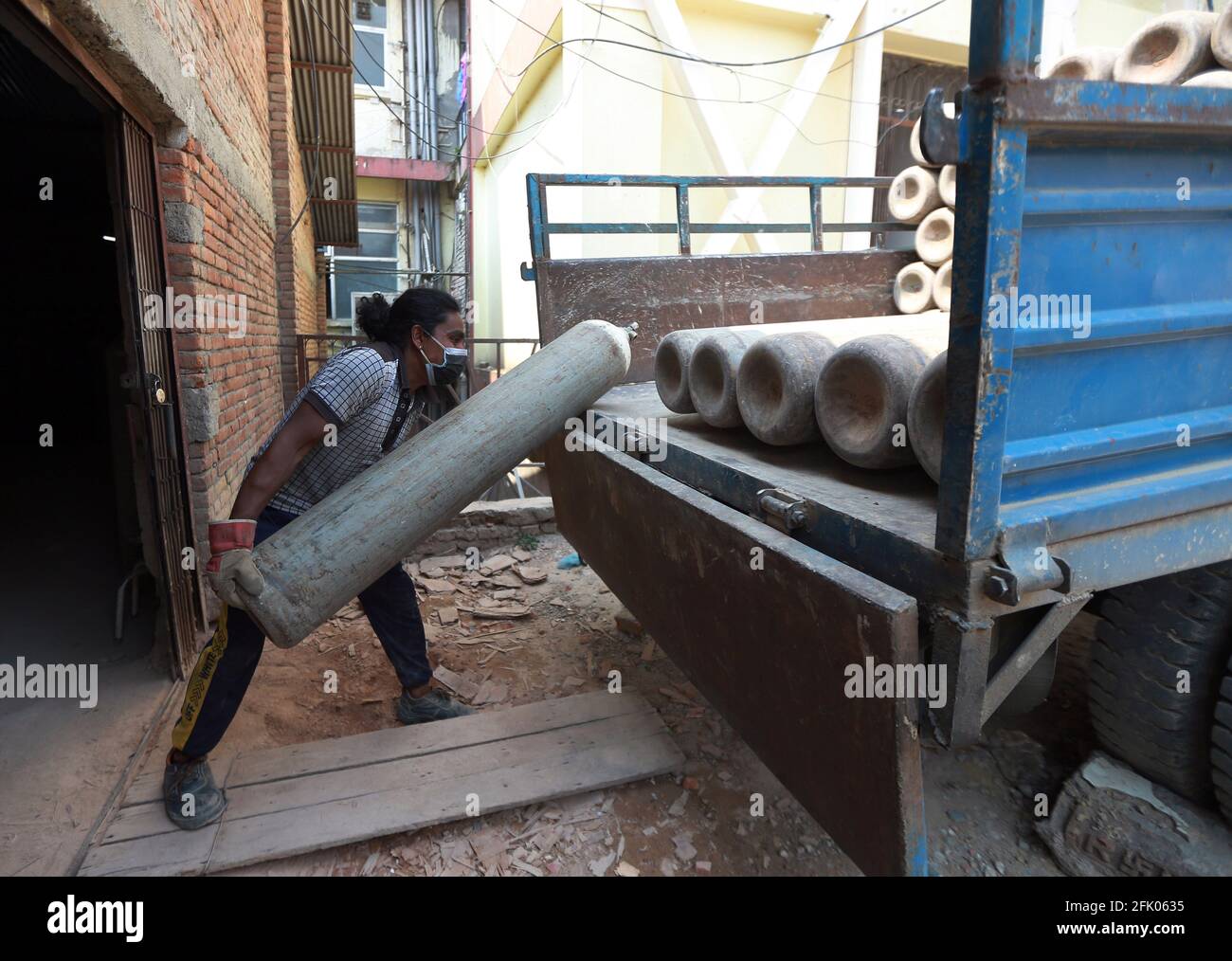 Kathmandu, Nepal. 27th Apr, 2021. A worker loads oxygen cylinders into a supply van to be transported to a hospital as the major second wave of the coronavirus disease (COVID-19) surges in Kathmandu, Nepal April 26, 2021. Credit: Dipen Shrestha/ZUMA Wire/Alamy Live News Stock Photo
