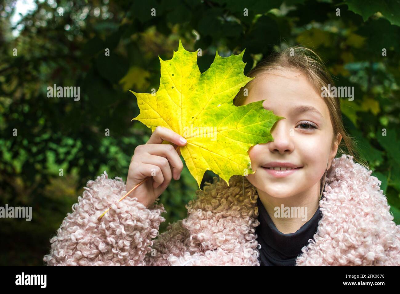 Cheerful girl with a maple leaf on her face. Autumn concept Stock Photo ...