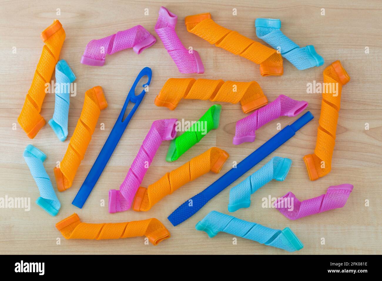 Colorful Hair Curlers, long spiral ringlets, leverage rollers with wand to speedy curl hair on wooden background Stock Photo