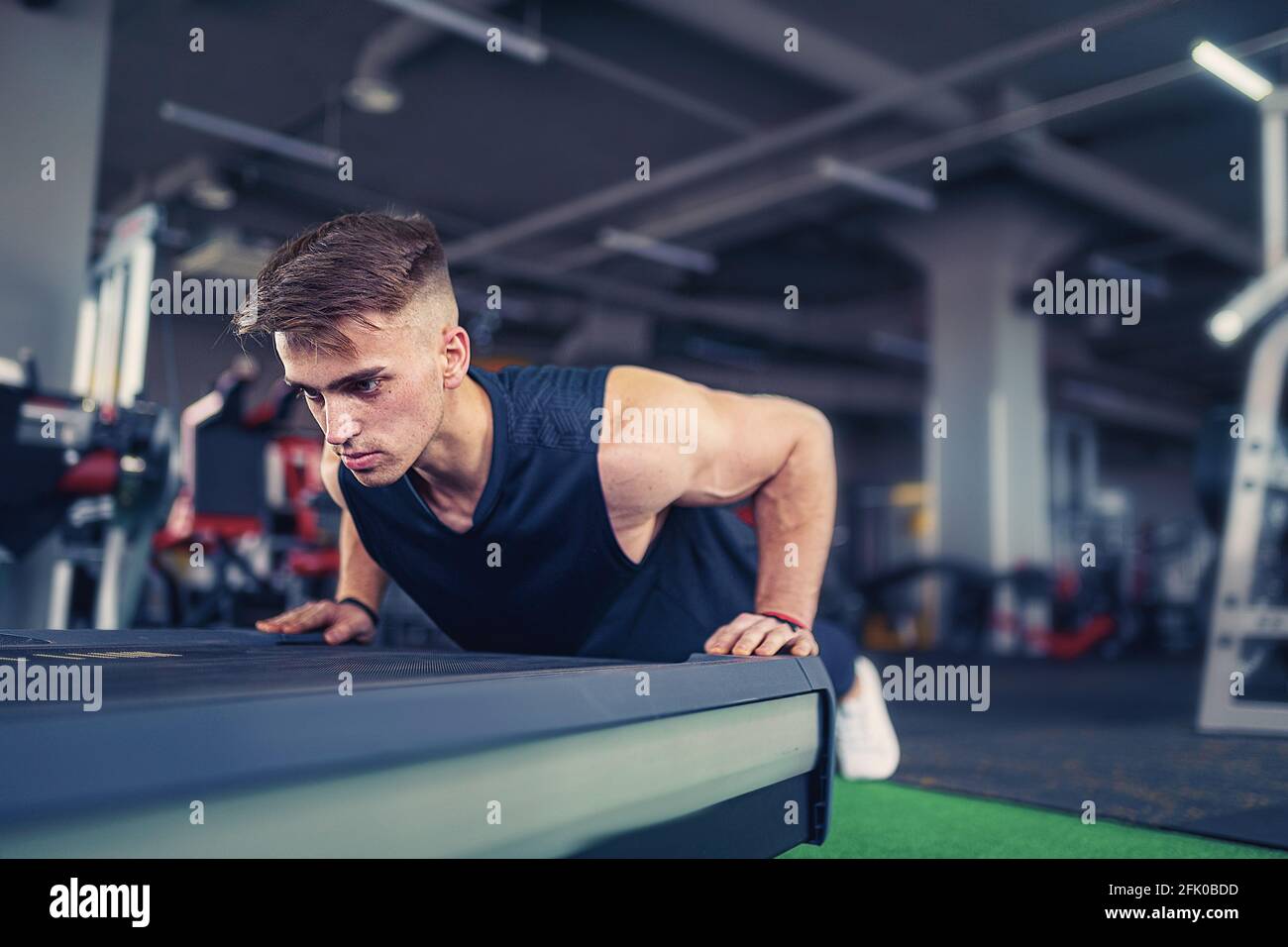 Young athletic man doing push-ups in gym. Muscular and strong gu Stock ...