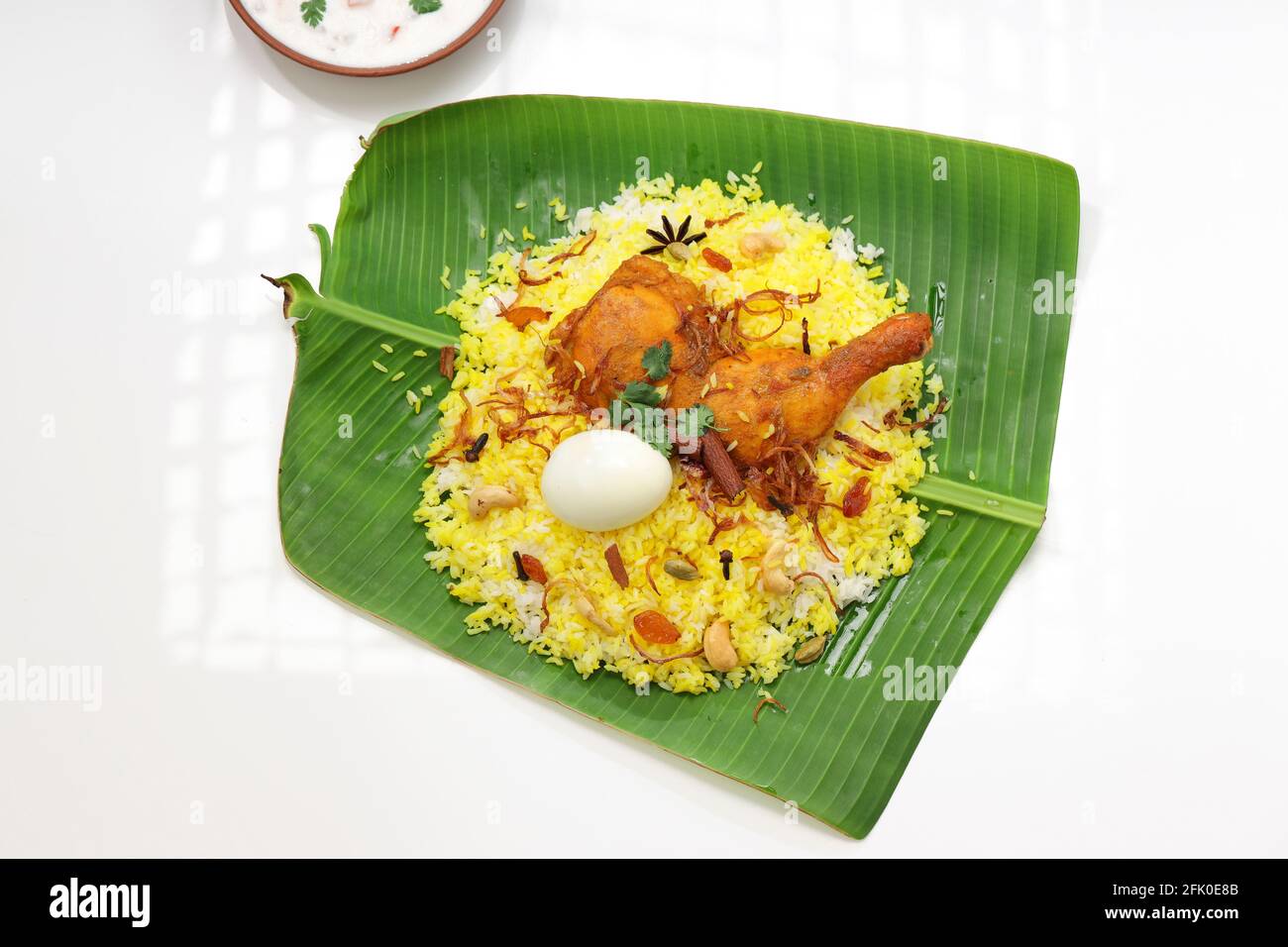 Dum Raita Kerala Chicken dum biryani ,arranged traditionally in a banana leaf and ...