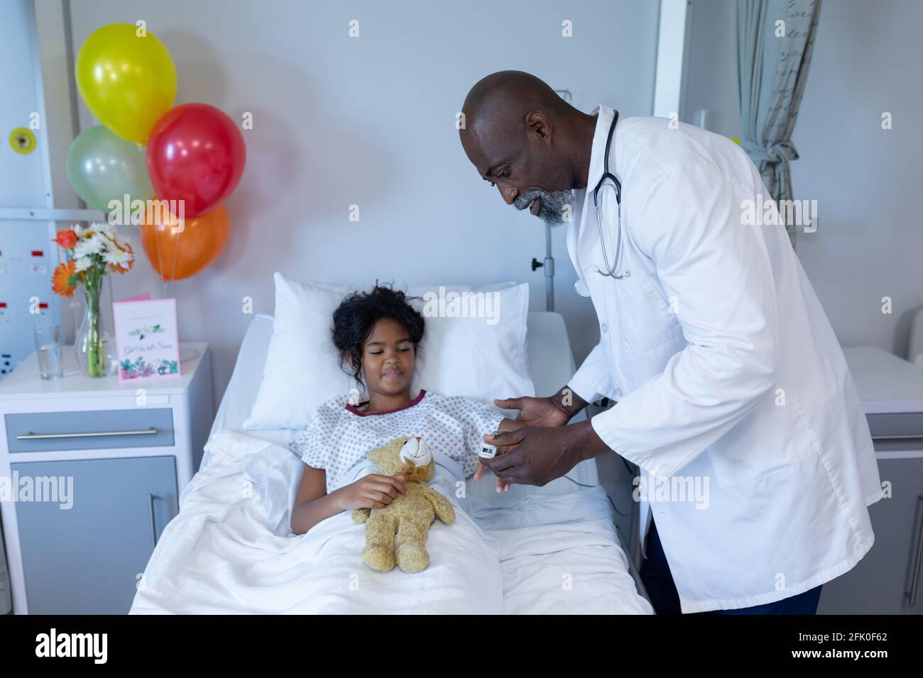 African american male doctor putting pulse oximeter on sick mixed race
