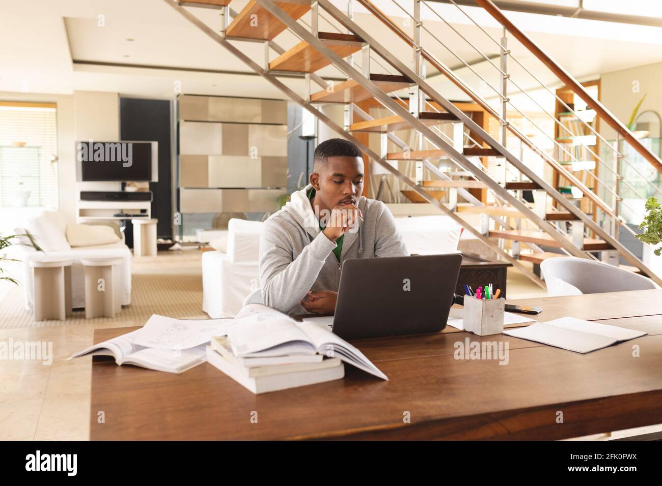 African american young man using laptop while studying at home Stock Photo