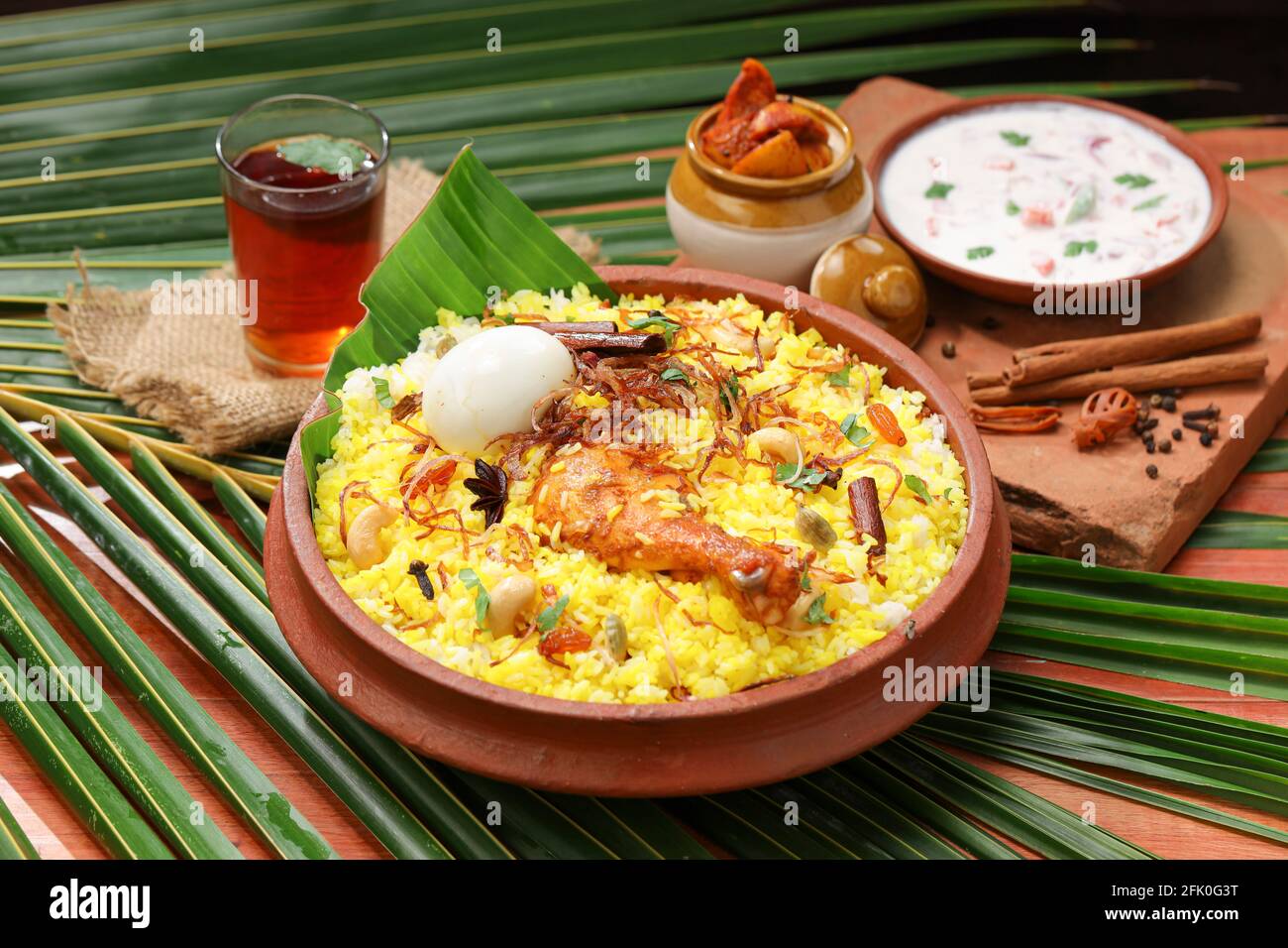 Chicken dum biryani , lemon pickle and raita as side dish and hot lemon