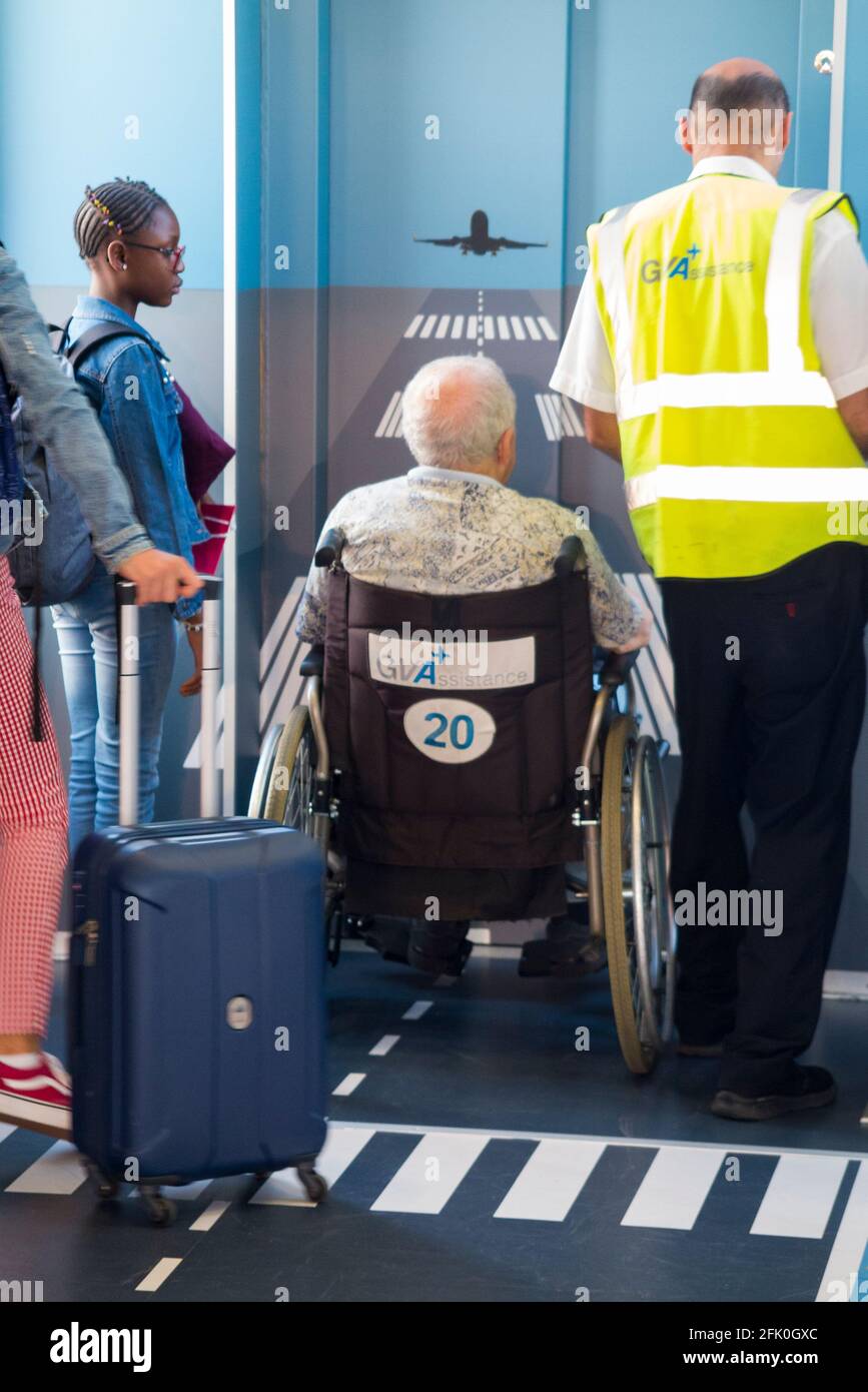 Disabled passenger with airport assistance wait to enter a lift whilst