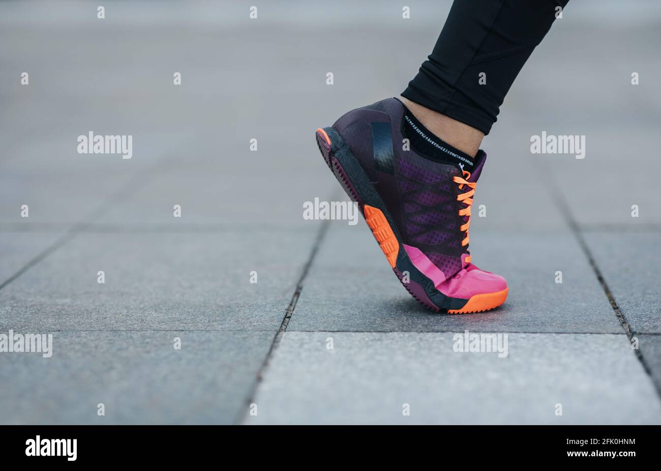Sports in city, workout outdoor, motivation, fitness, jogging and health care in outdoor. Leg of athlete african american lady in trend sneaker runs o Stock Photo