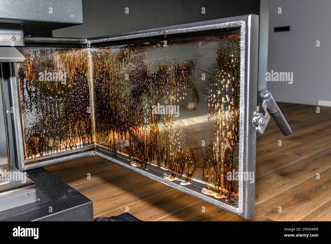 Cleaning the corner glass from soot in a modern fireplace with a closed
