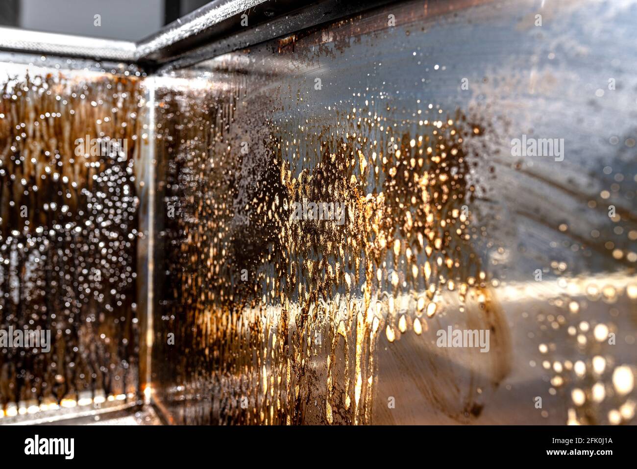 Cleaning the corner glass from soot in a modern fireplace with a closed