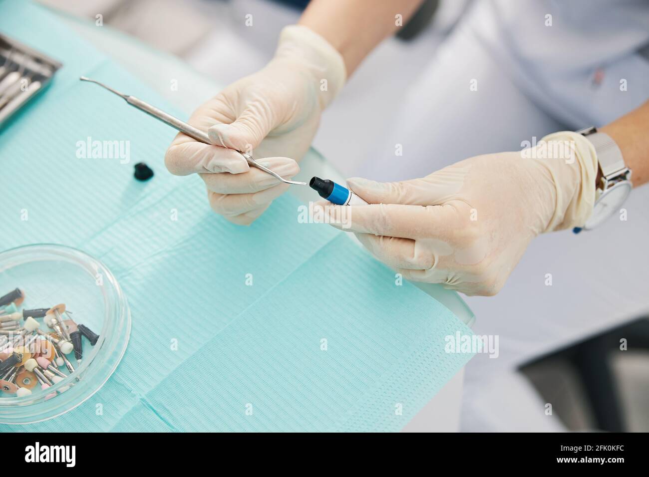 Person dipping dental instrument in dental composite filling bottle Stock Photo