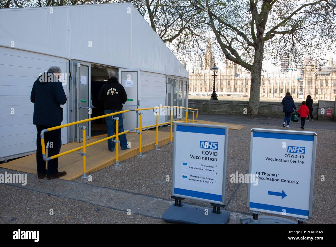 London, UK, 27 April 2021: people queue at the endtrance to a vaccination centre in the grounds of St Thomas's Hospital, facing the Houses of Parliament on the opposite bank of the River Thames. Prime Minister Boris Johnson still faces accusations of having preferred that 'bodies pile up' rather than have a third lockdown. Anna Watson/Alamy Live News Stock Photo