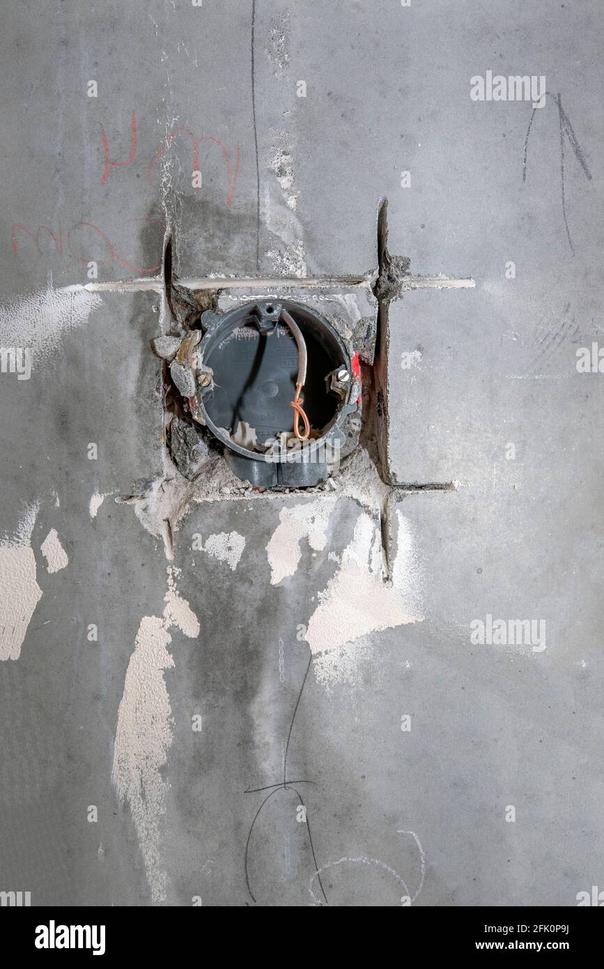 Electrical wire and opened junction box on the concrete wall