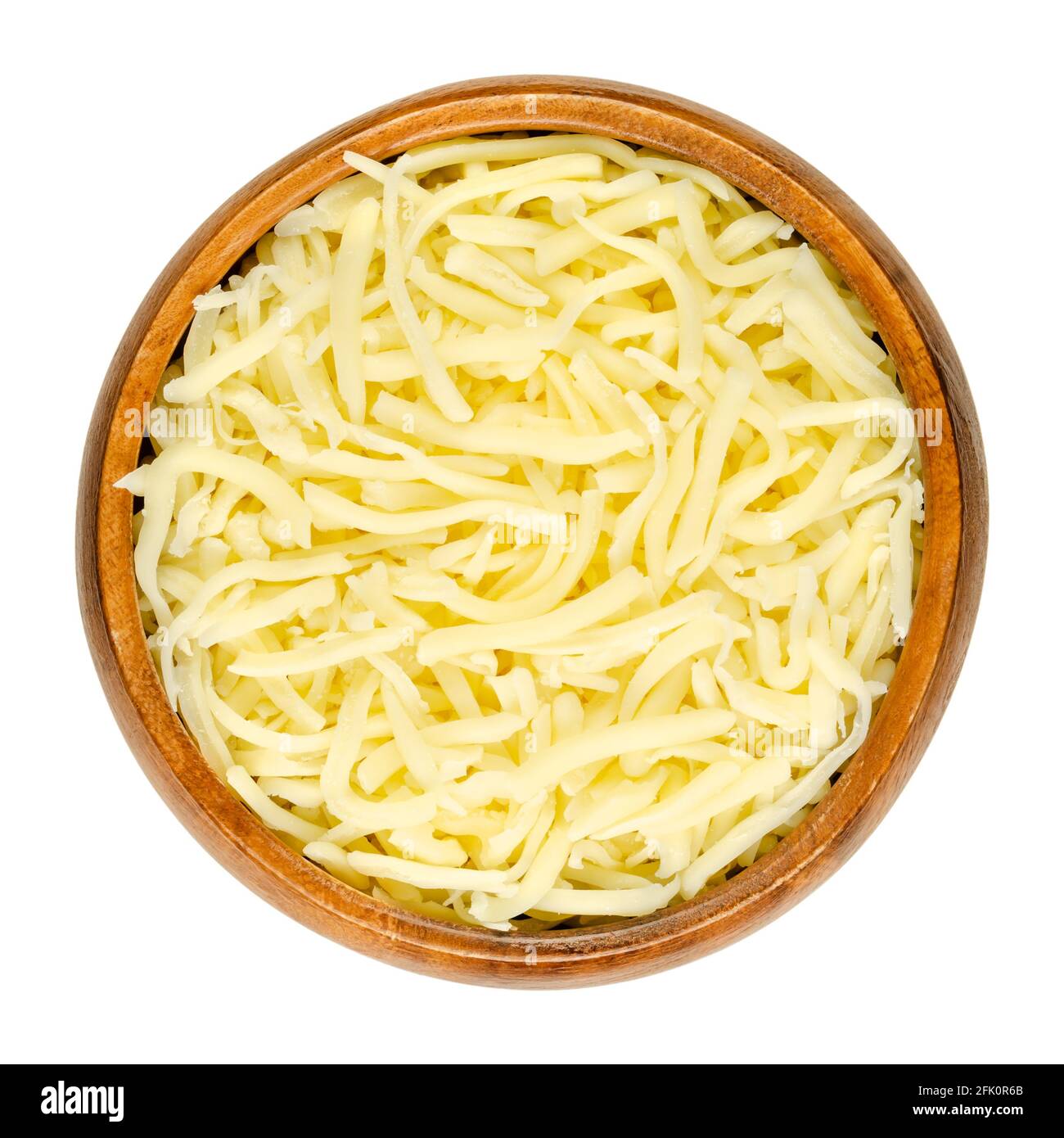 Grated pizza cheese, in a wooden bowl. Softly melting, shredded semi-hard cheese, made of pasteurized milk, rolled in starch to avoid sticking. Stock Photo