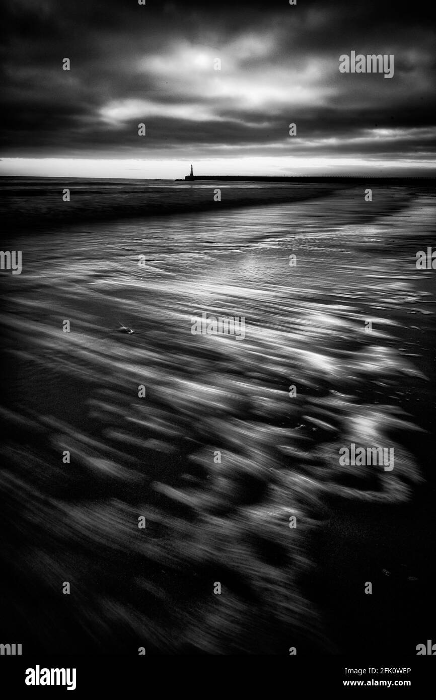 A black and white portrait photo of Roker Lighthouse at the mouth of the River Wear in Sunderland, a city in the north east of England. Stock Photo