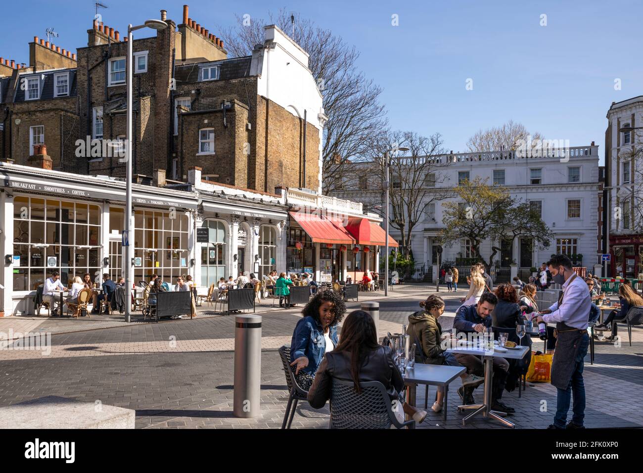 People sat outside cafes and restaurants on Exhibition Road after covid lockdown eased, South Kensington, London, United Kingdom, Europe Stock Photo