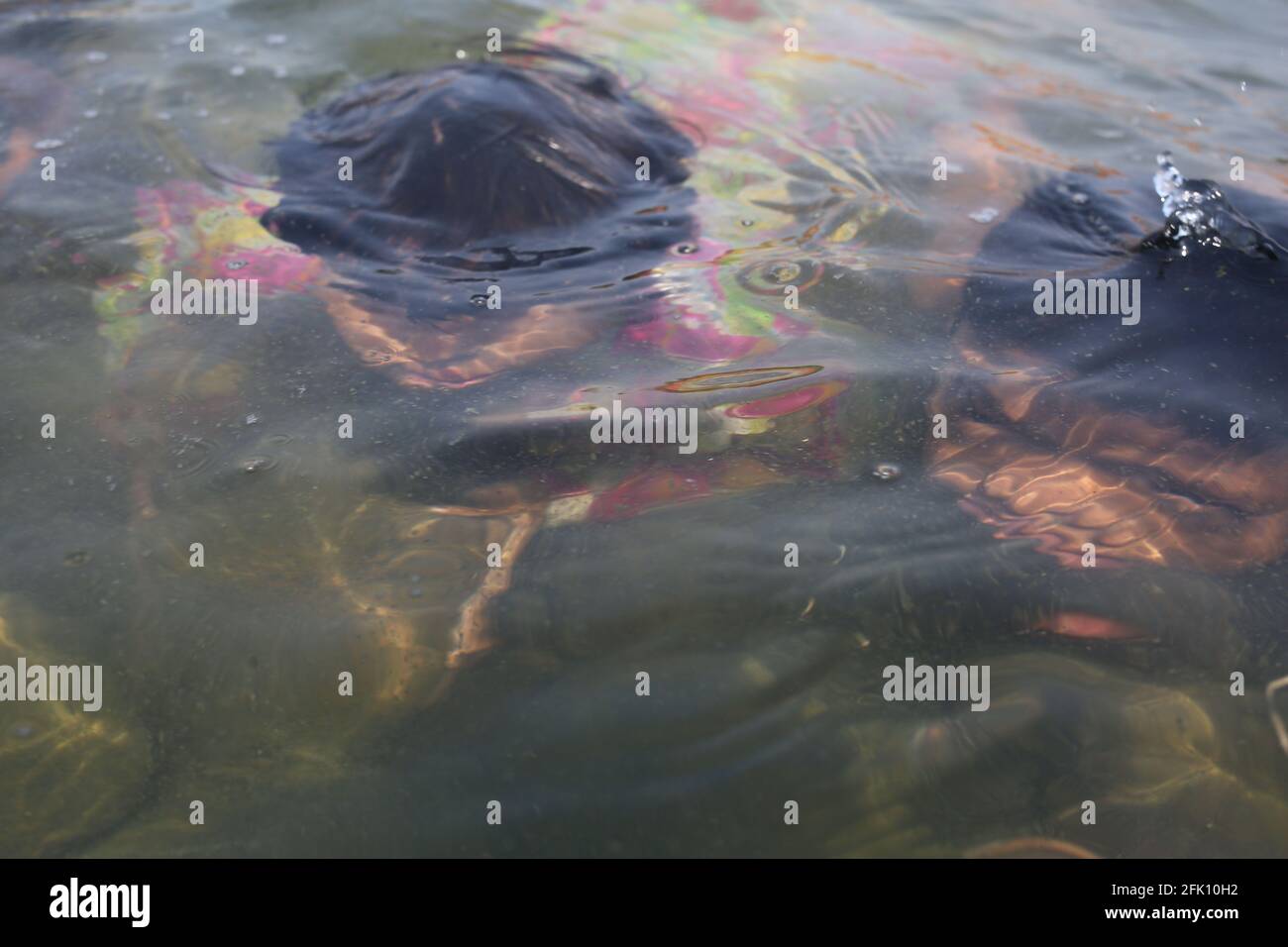 Dhaka, Bangladesh. 27th Apr, 2021. Public life in Bangladesh is disrupted by intense heat. In the scorching heat, the children bathed in the water of the lake in front of the Independence Pillar in the capital Dhaka during lockdown caused by COVID-19 pandemic. Credit: Md. Rakibul Hasan/ZUMA Wire/Alamy Live News Stock Photo