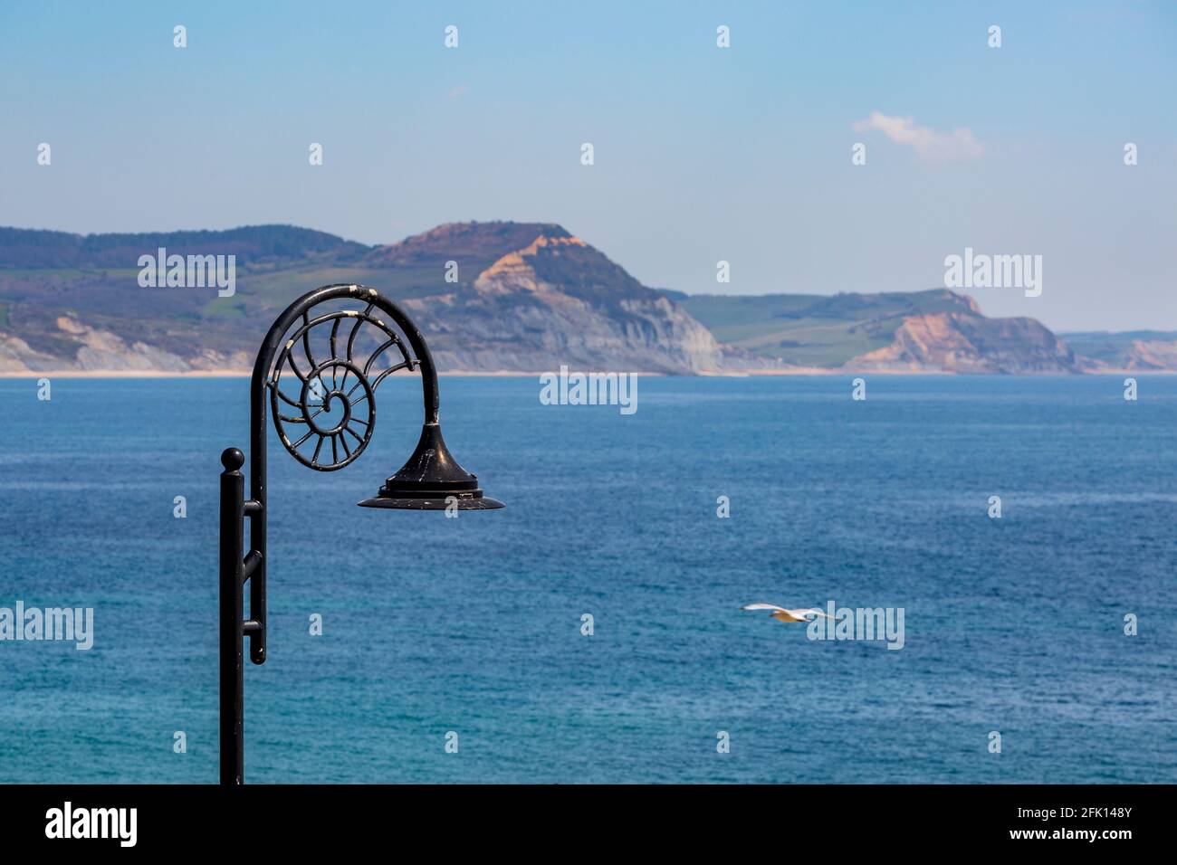 A Lyme Regis Ammonite lampost with the Jurassic Coast in the background, Dorset, England Stock Photo