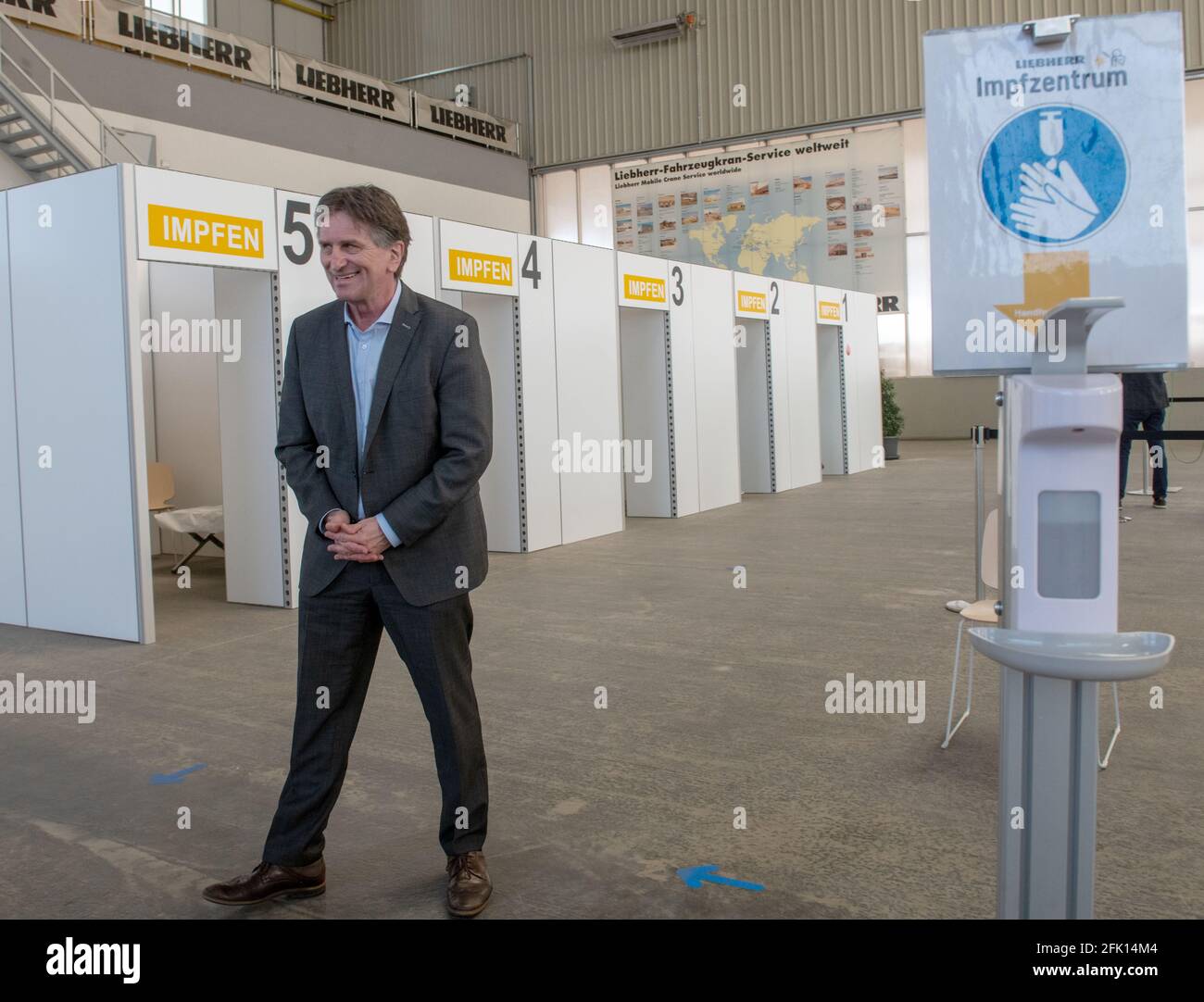 Ehingen, Germany. 27th Apr, 2021. Manfred (Manne) Lucha (Bündnis90/Die Grünen), Minister for Social Affairs and Integration of Baden-Württemberg, stands in the vaccination centre of the machine manufacturer Liebherr. The Liebherr plant in Ehingen was selected as a pilot plant for vaccinations by company doctors in Baden-Württemberg. The state's well-known vaccination prioritisation applies, so that employees aged 60 and over will be vaccinated as a first step. Credit: Stefan Puchner/dpa/Alamy Live News Stock Photo